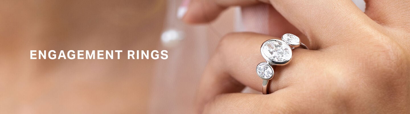 Luxury diamond engagement ring beside a bride in a veil, showcasing Fields engagement rings.